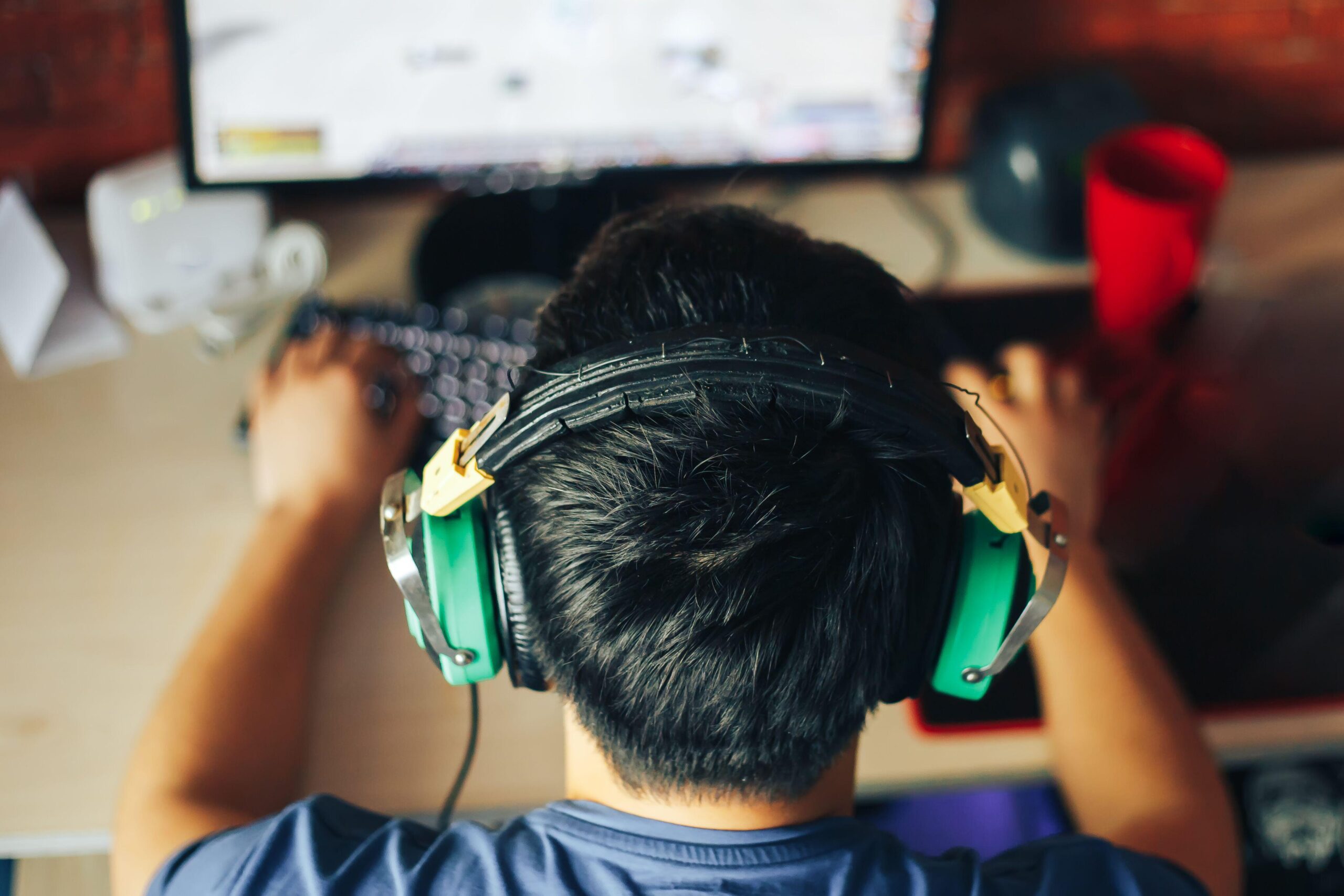 a man wearing headphones while playing Civ VII on his home PC